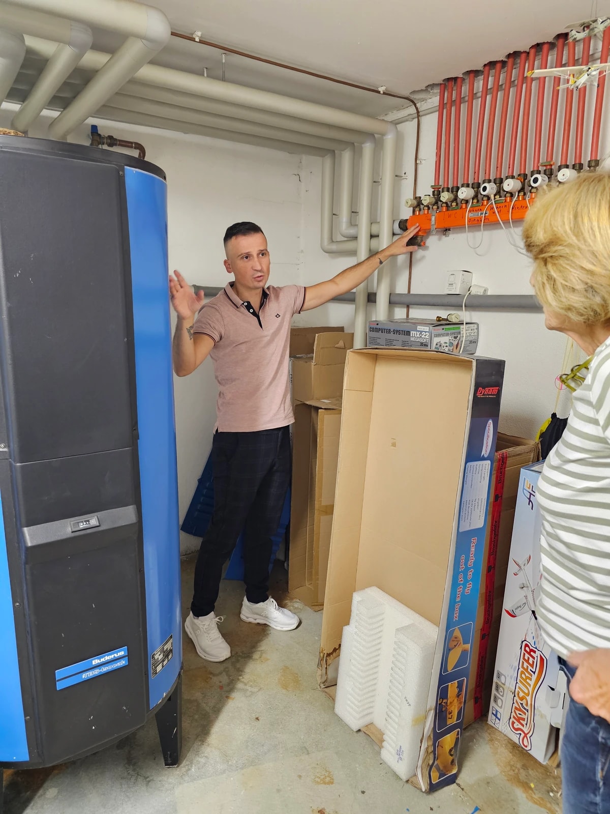 Heizungsmeister bespricht die bestehende Heizungsanlage und den Heizungsverteiler vor Ort.